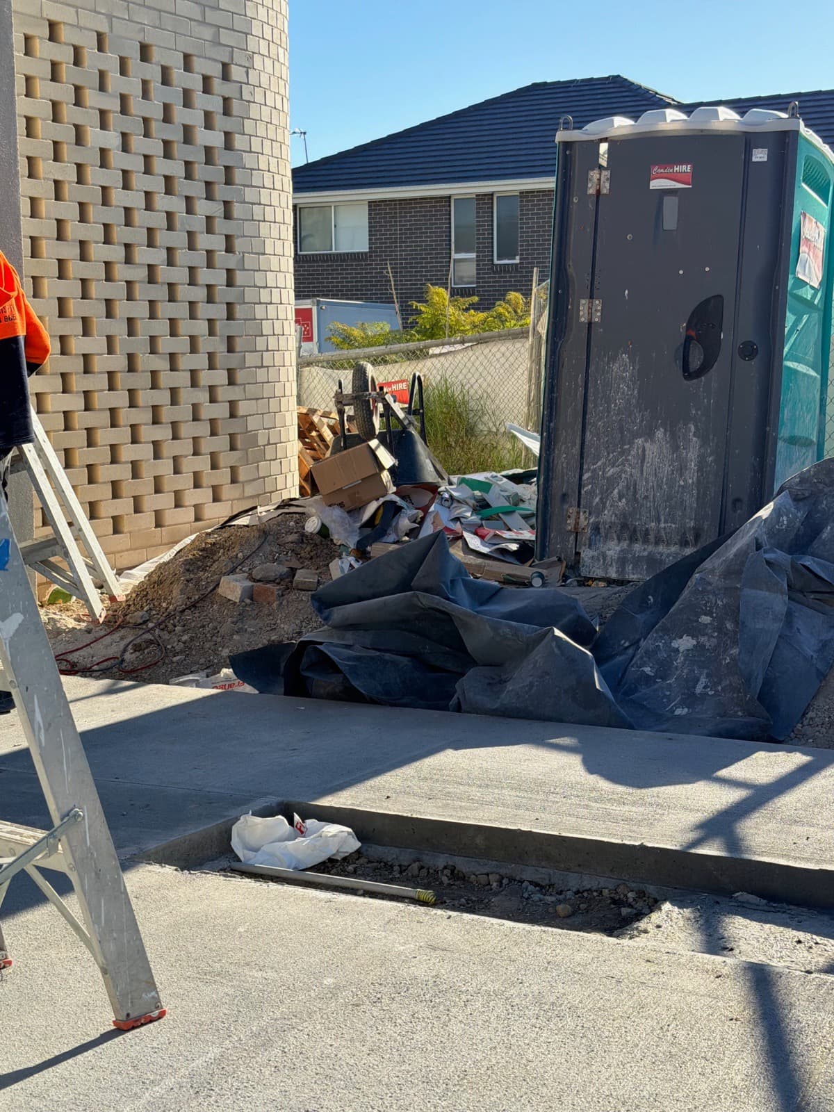 Construction debris, tarps and offcuts piled up on a job site